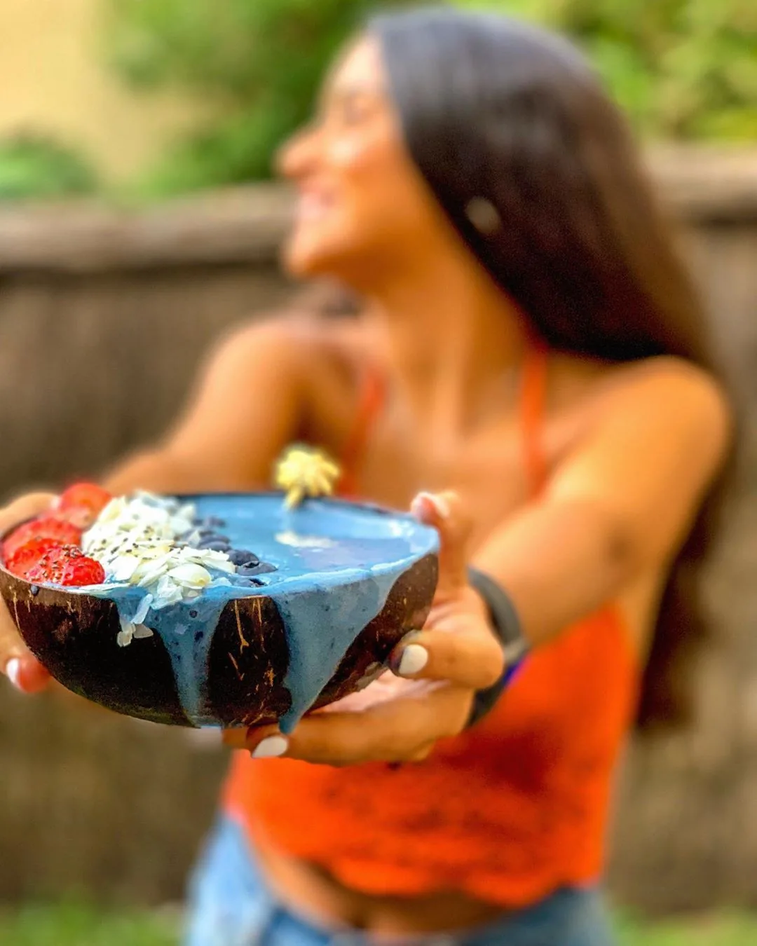 A blue smoothie served in a coconut bowl