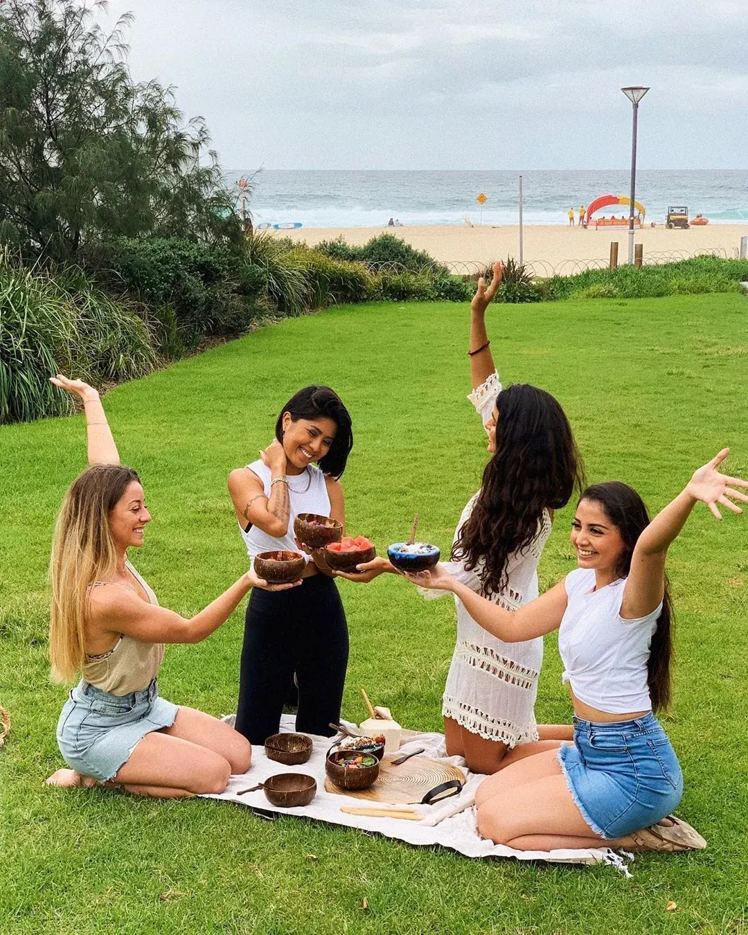 Friends enjoying coconut bowls together near the beach