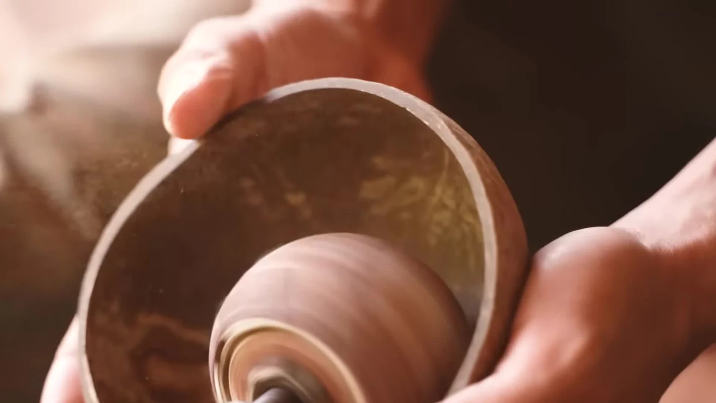 Close-up of hands polishing the inside of a coconut shell